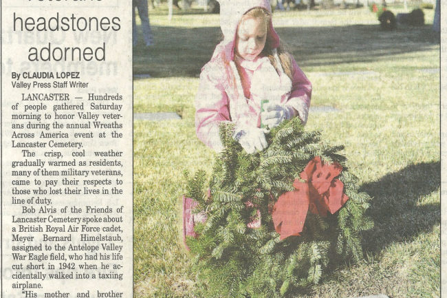 Newspaper clipping showing photo of girl laying a wreath on veteran grave